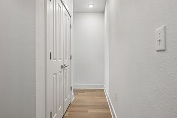 A white door with a light switch on the wall.